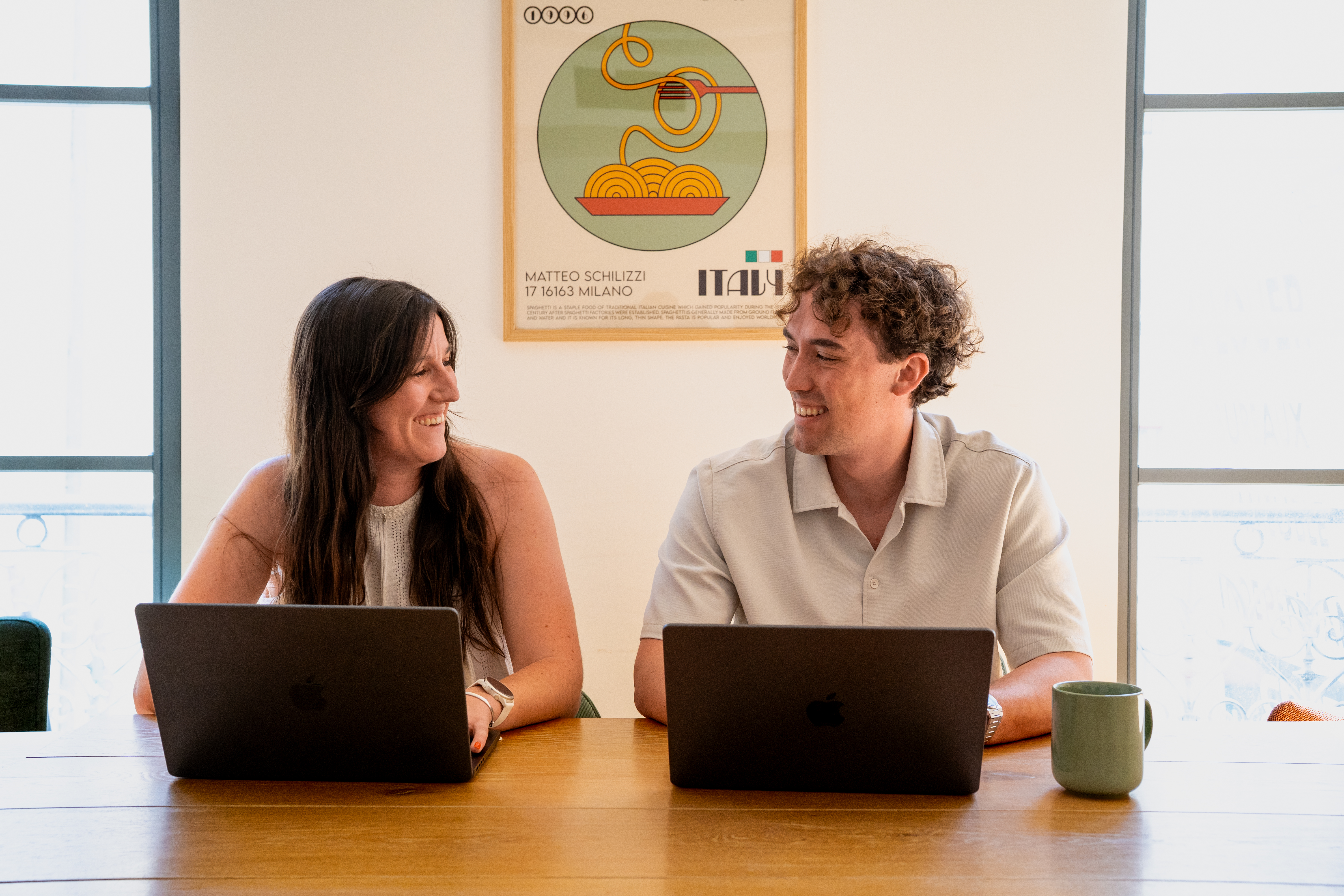 Dois colaboradores da Galadrim a conversar em frente aos computadores