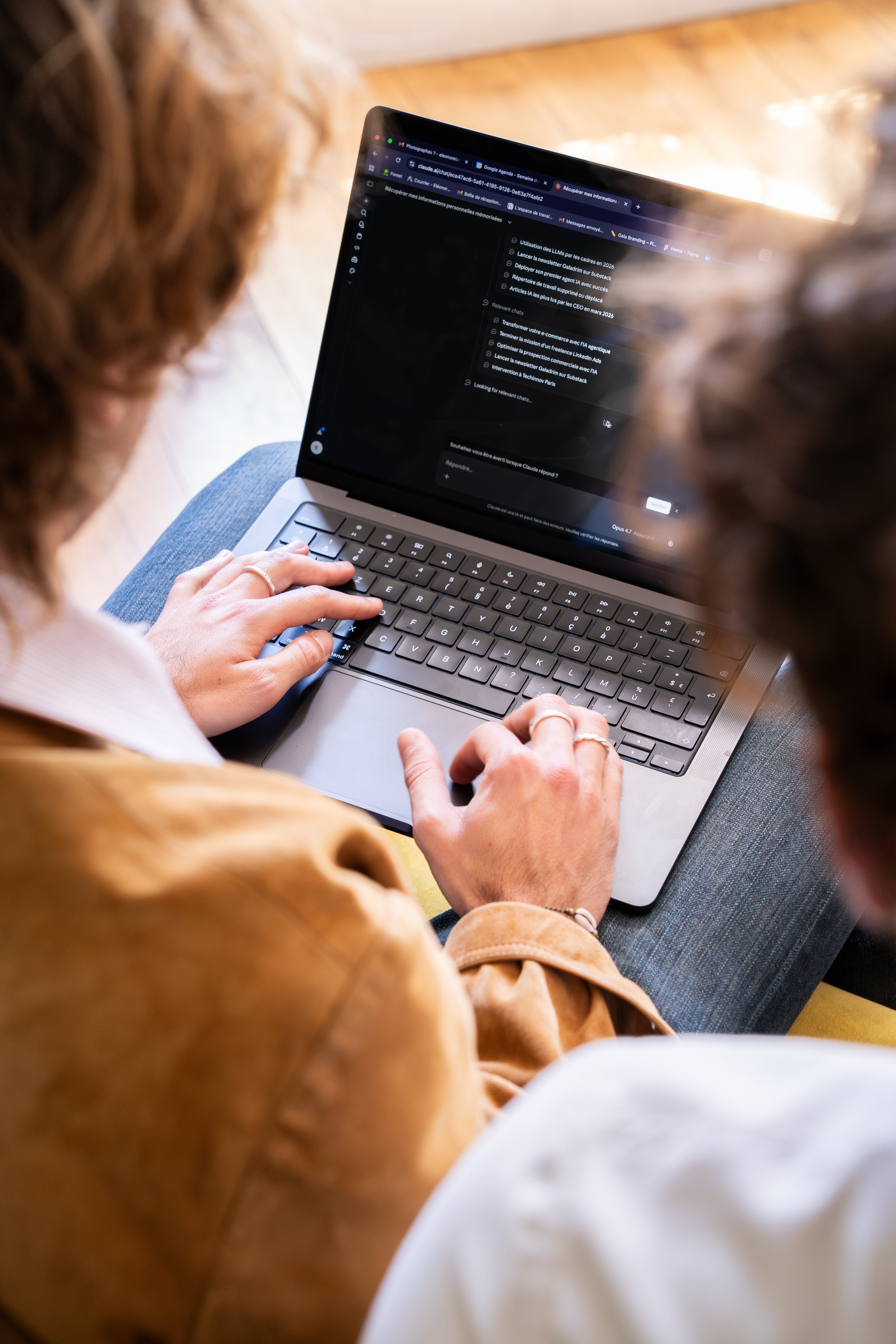 Duas pessoas em frente a um computador portátil que mostra uma interface de chat com IA