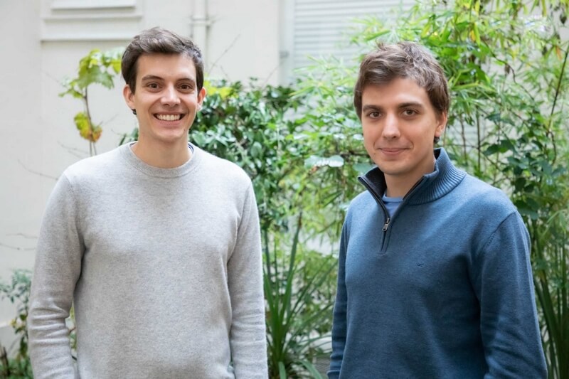 Jean Ashton e Arnaud Albalat, os dois fundadores da Galadrim, em pé em frente a uma parede de plantas.