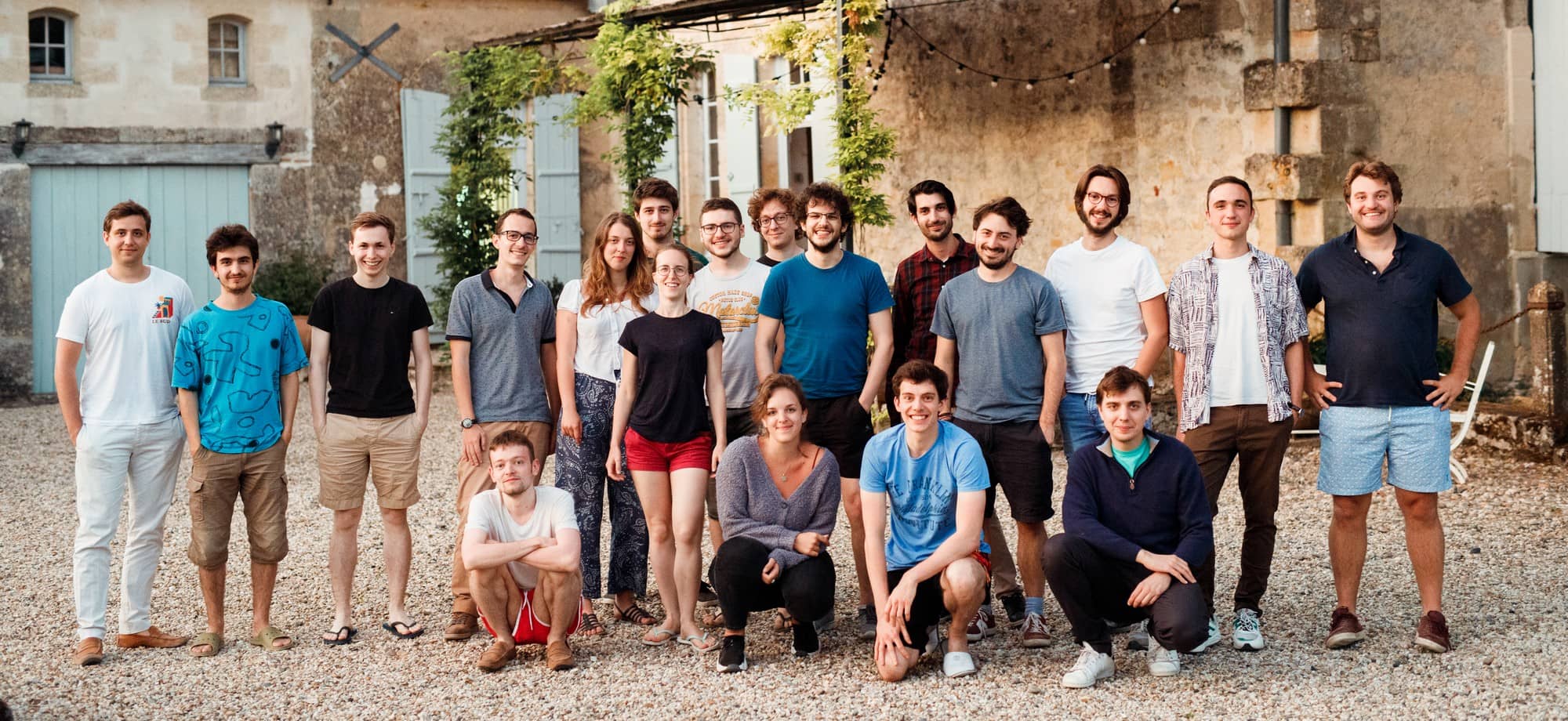 A equipa da Galadrim reunida no pátio de um edifício de pedra, durante um seminário.